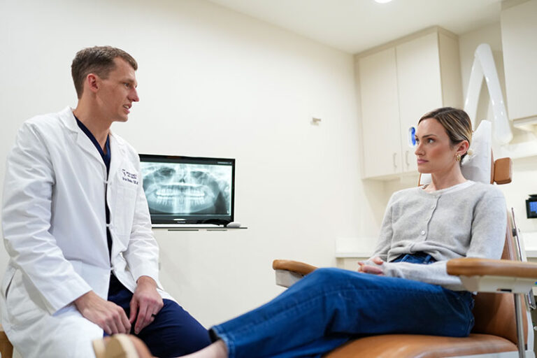 Dr Bhaskar talking to a patient in a dental chair