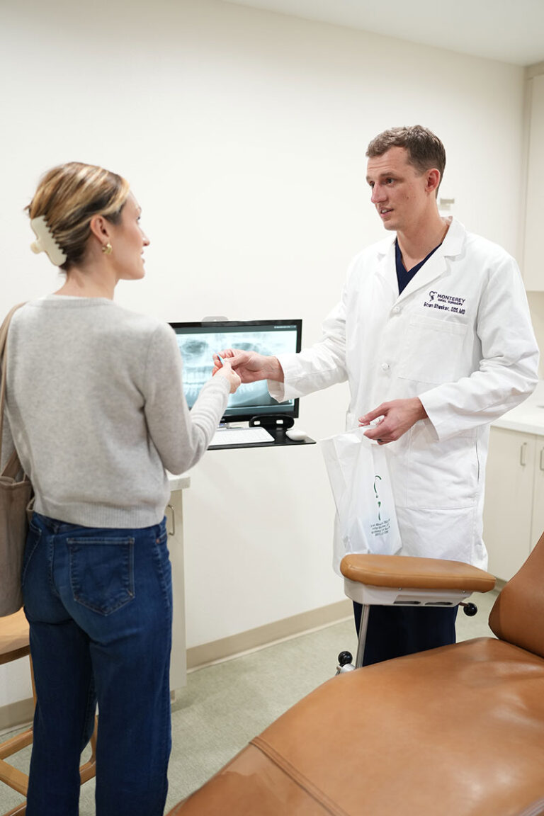 Dr Brian Bhaskar handing something to a patient